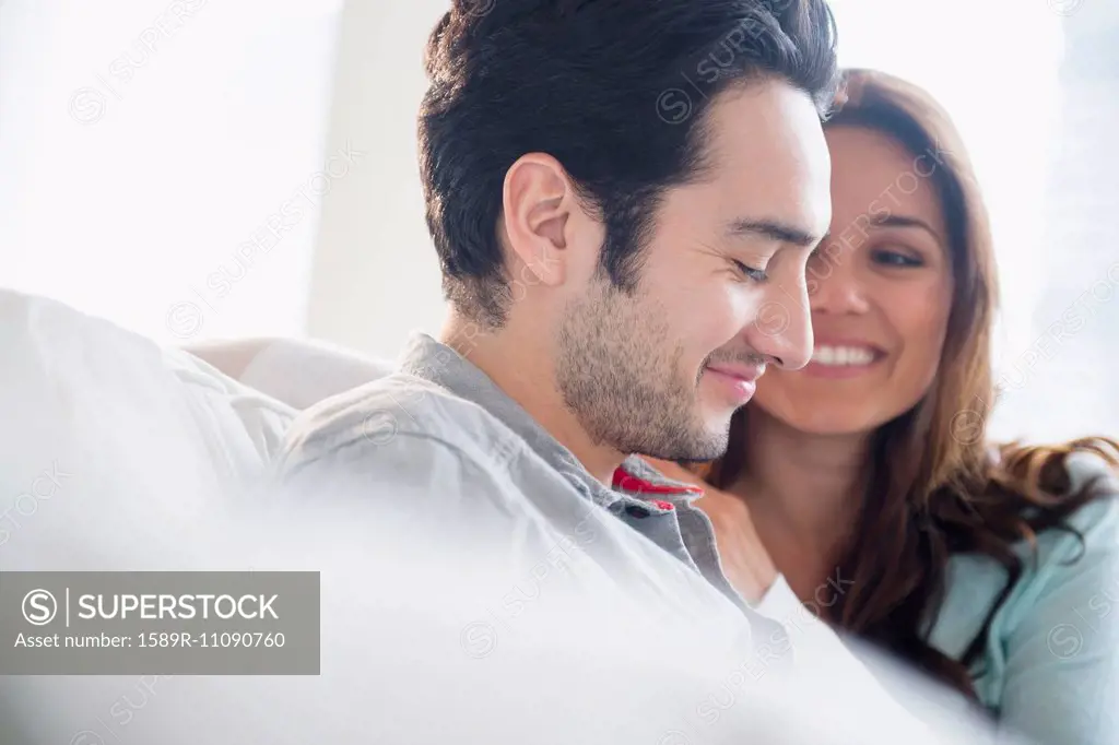 Couple smiling together on sofa