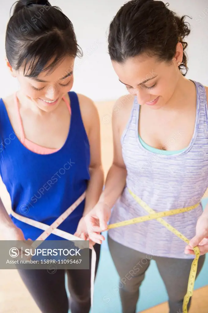 Women measuring their waists