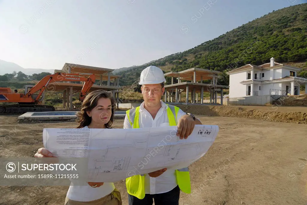 Engineer and architect looking at plan on construction site