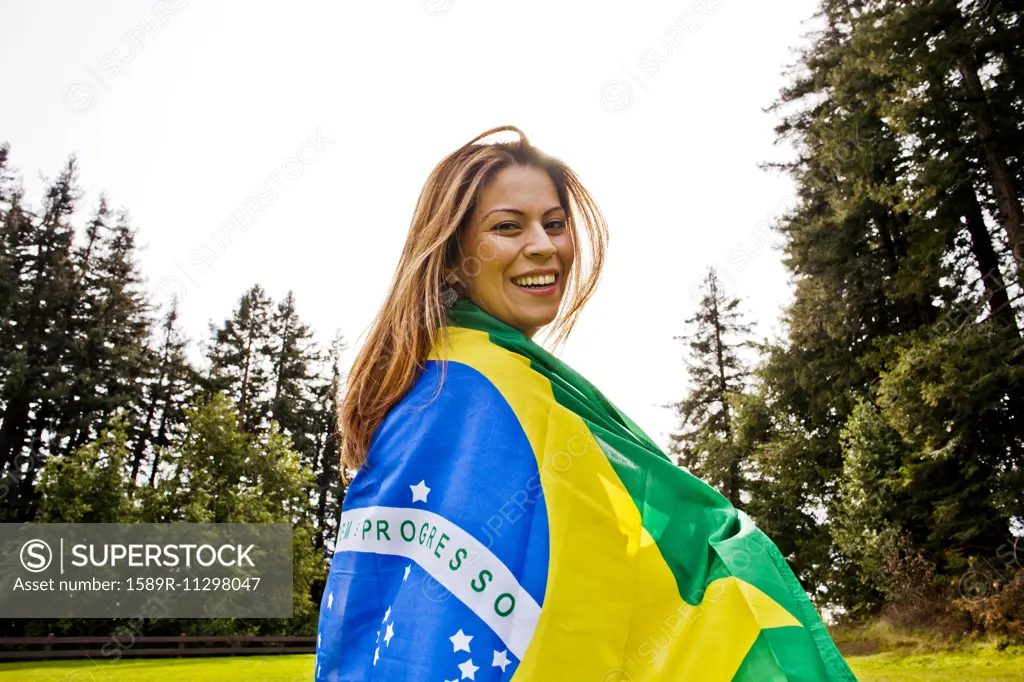 Hispanic woman wrapped in Brazilian flag