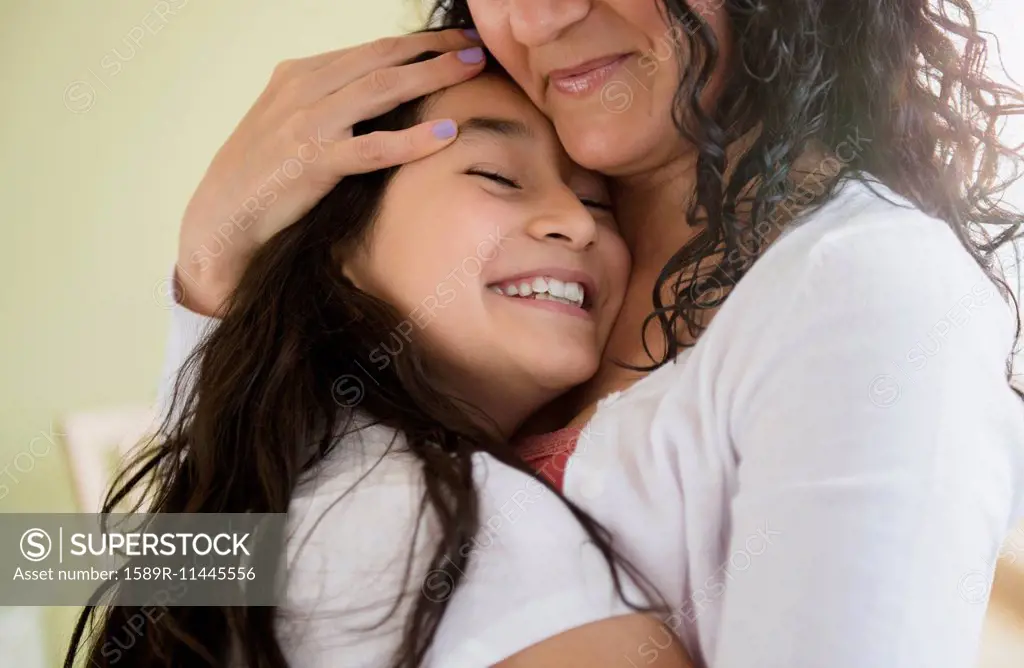 Hispanic mother and daughter hugging