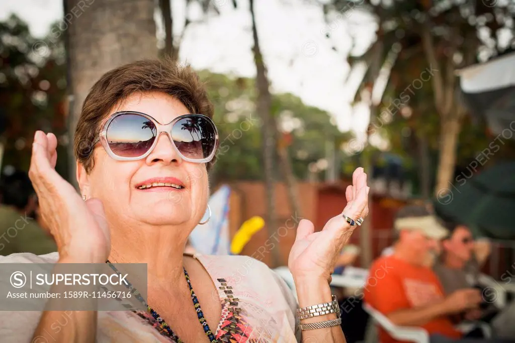 Older woman clapping outdoors