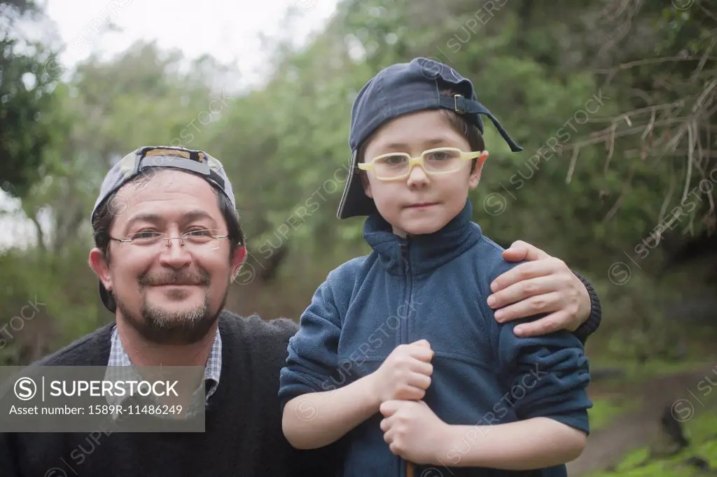 Hispanic father and son hugging in park