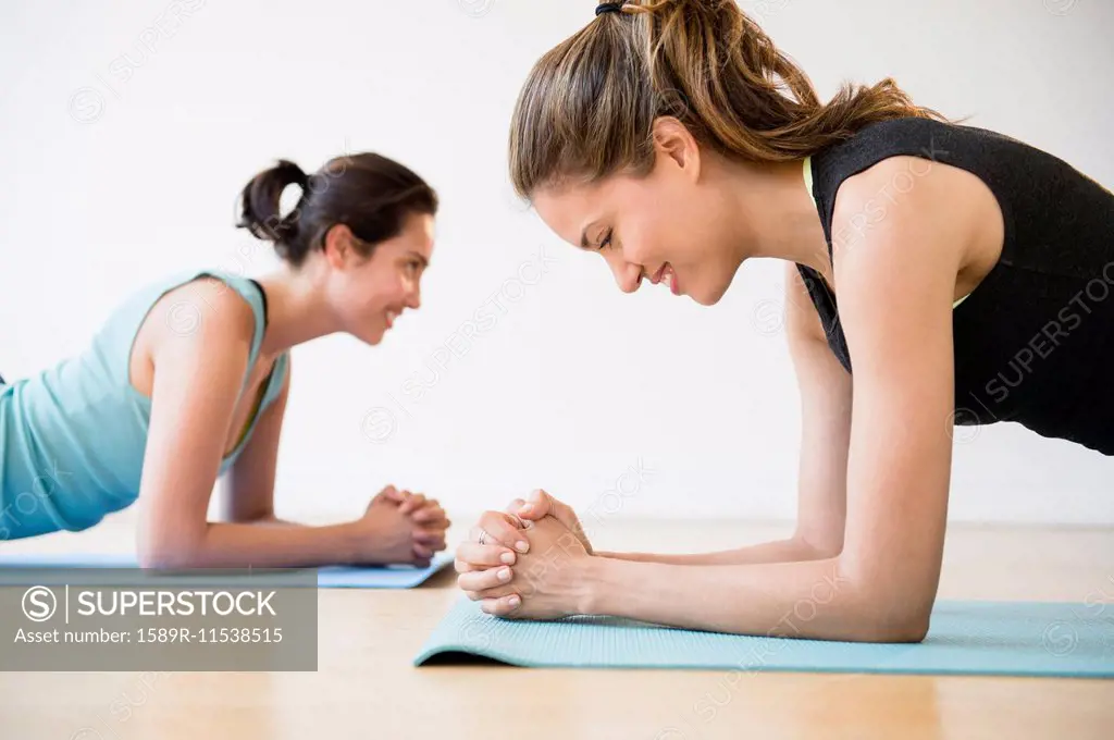 Hispanic women practicing yoga in studio