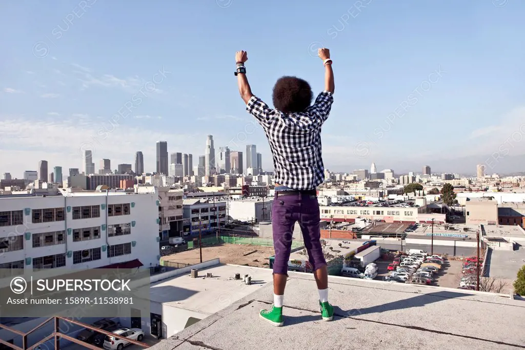 African American man overlooking cityscape from urban rooftop