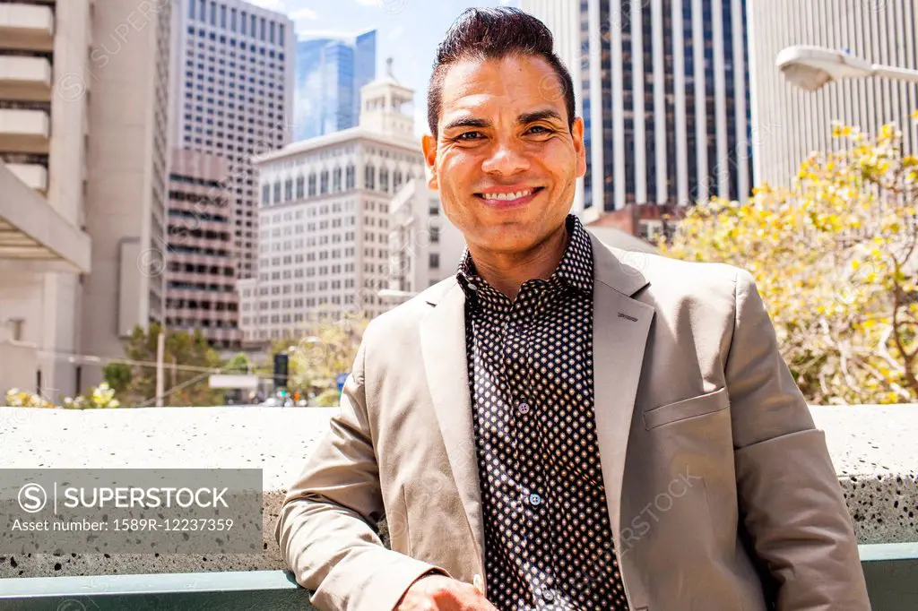 Hispanic businessman smiling in city,