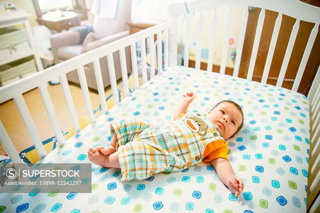 Caucasian baby boy laying in crib