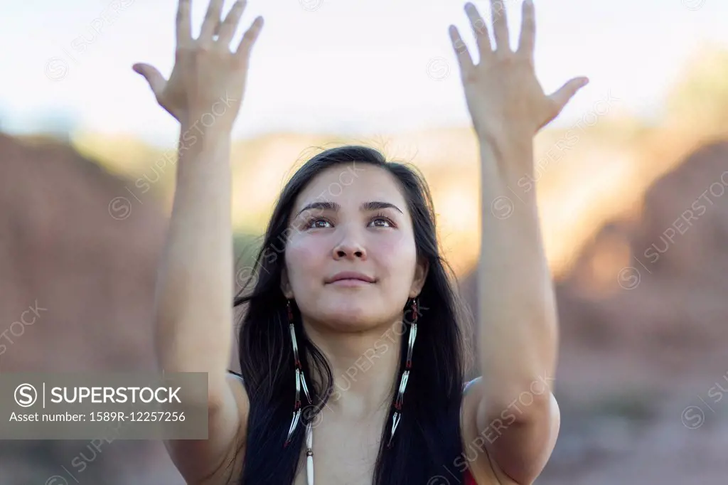 Mixed race woman meditating in desert