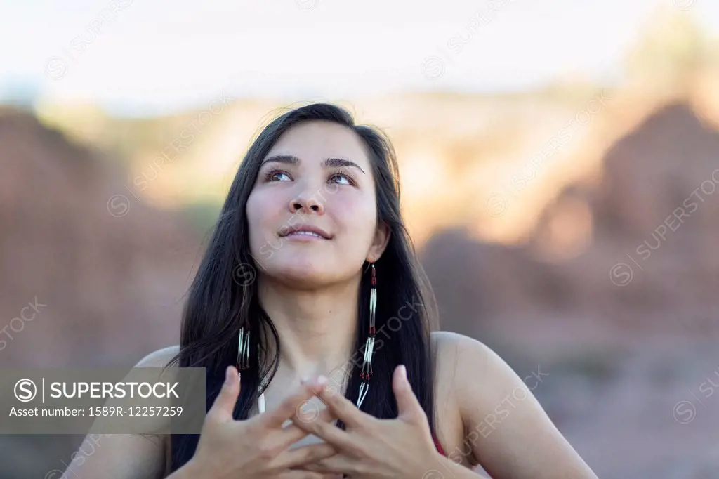 Mixed race woman meditating in desert