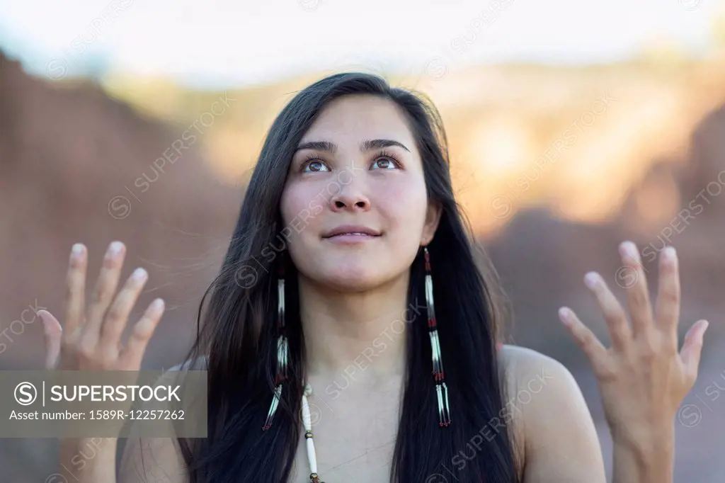 Mixed race woman meditating in desert