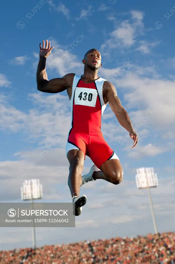 Black high jumper in mid-air at track & field event