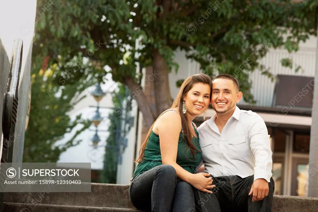 Hispanic couple sitting together on steps