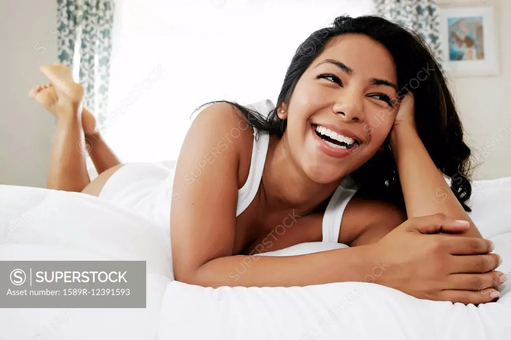 Hispanic woman laying on bed