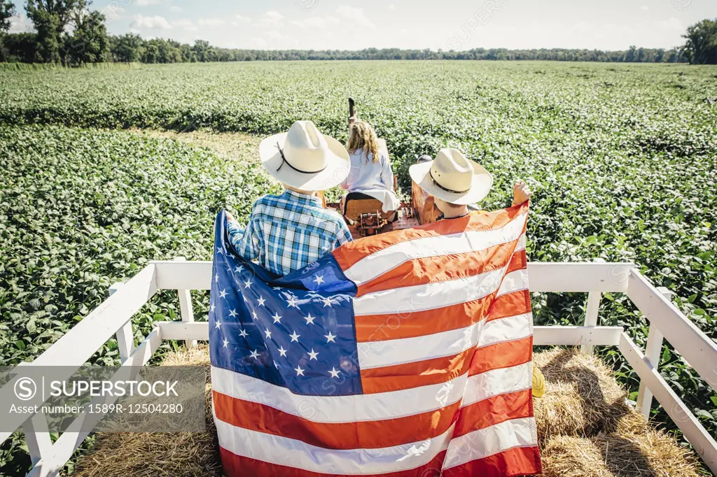 Caucasian children holding American flag on hay ride