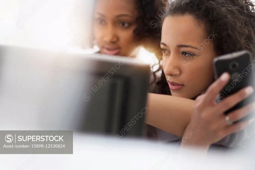 Businesswomen working with cell phone and computer