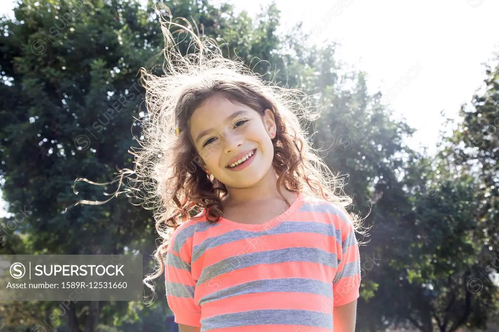 Smiling Hispanic girl standing outdoors