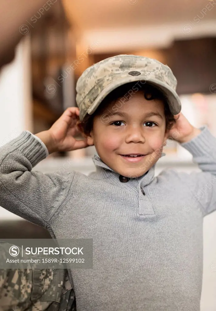 Mixed race boy wearing soldier cap