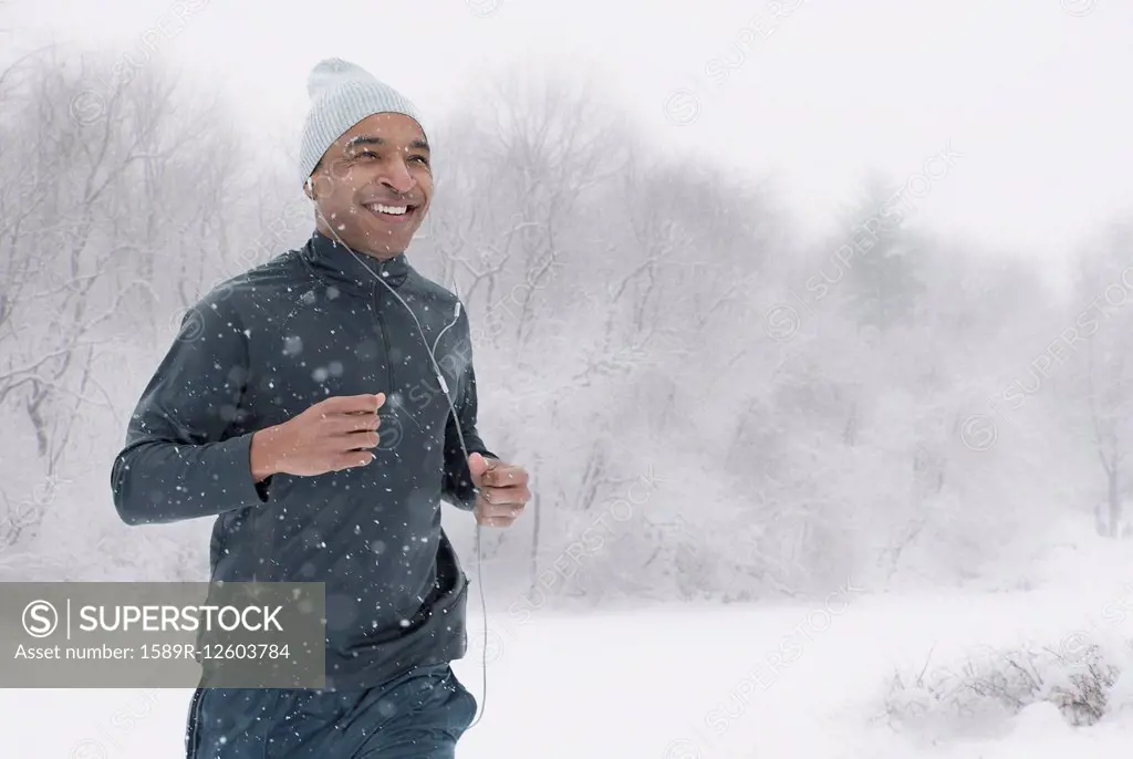 Black runner jogging in snow