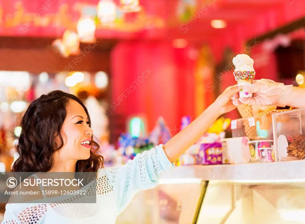 Chinese woman buying ice cream cone in shop