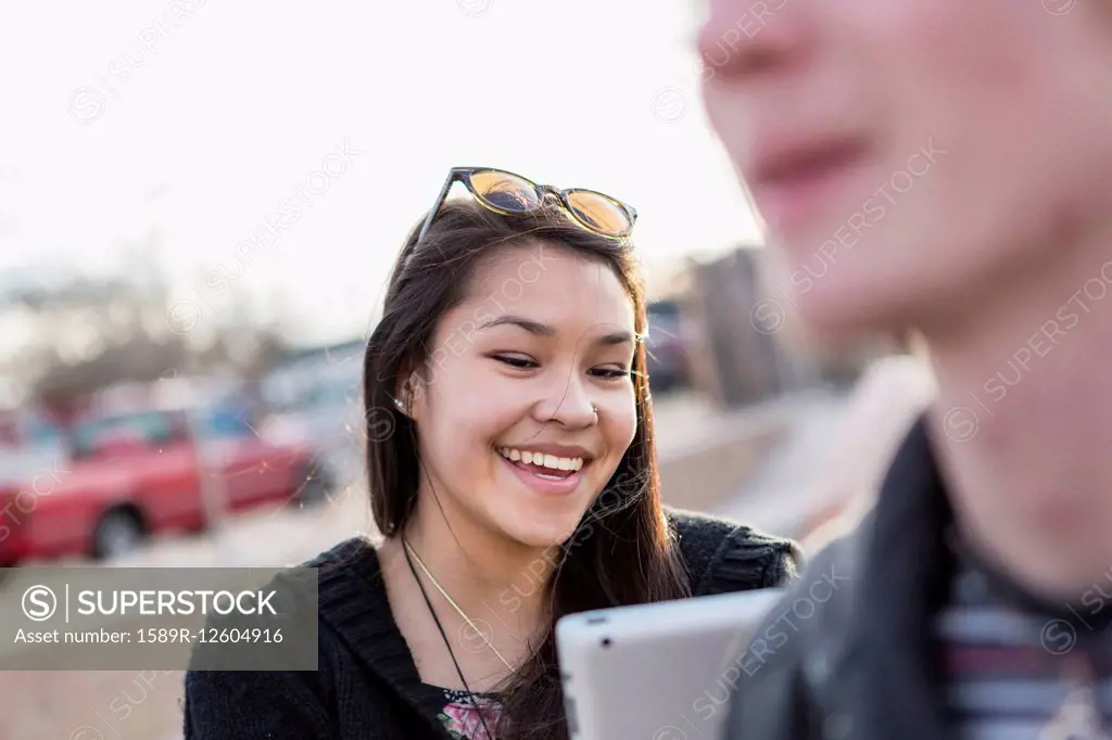 Teenage girl using digital tablet outdoors