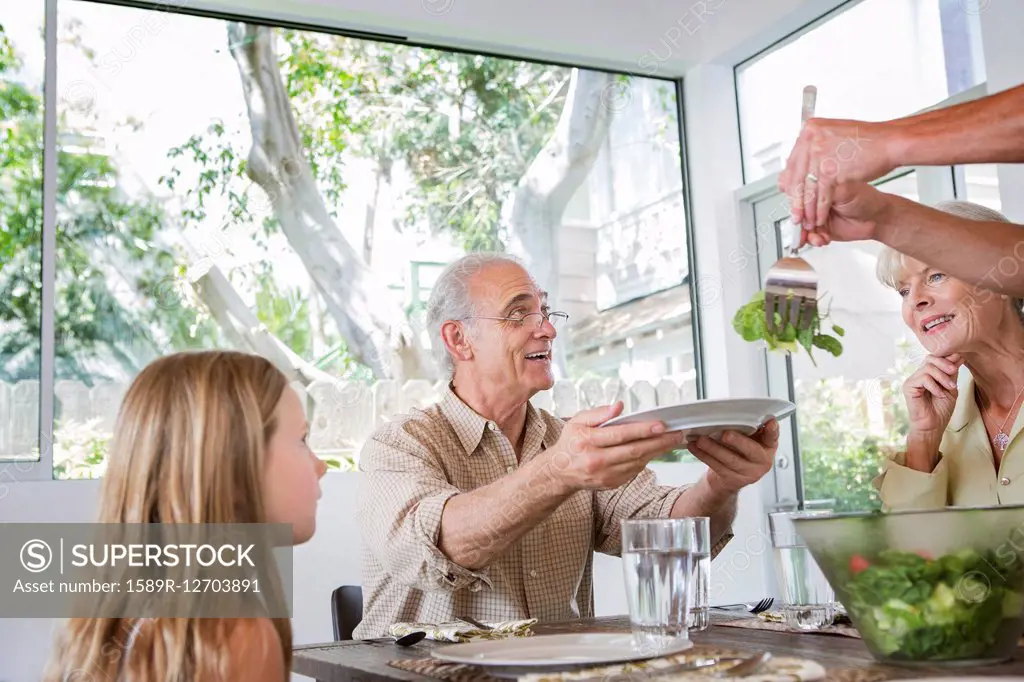 Caucasian multi-generation family eating at table