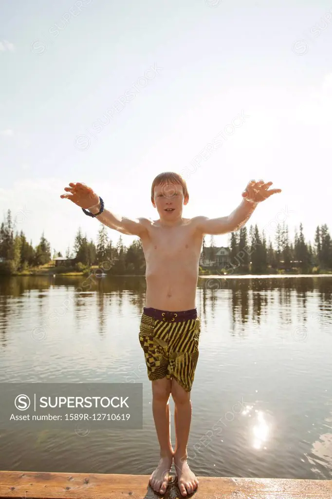 Caucasian boy falling backwards into lake
