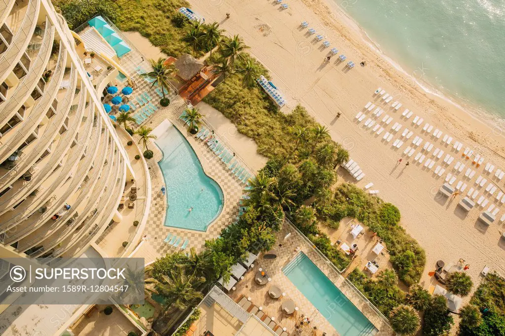 Aerial view of hotel pools and tropical beach