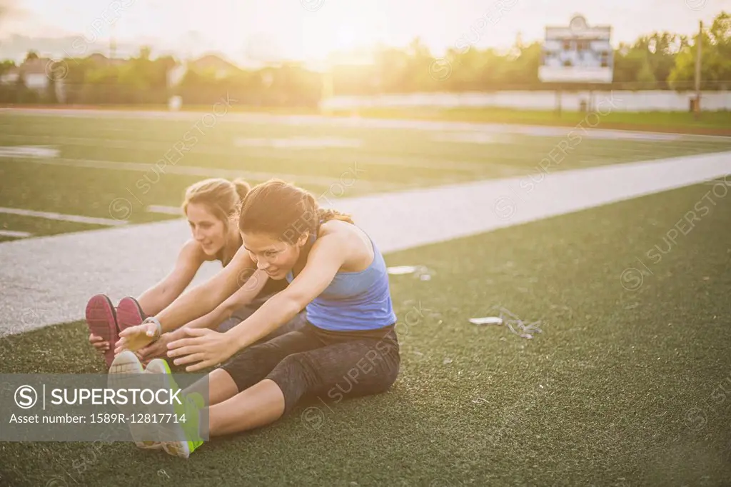 Athletes stretching on sports field