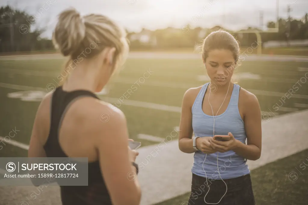 Athletes listening to mp3 players on sports field