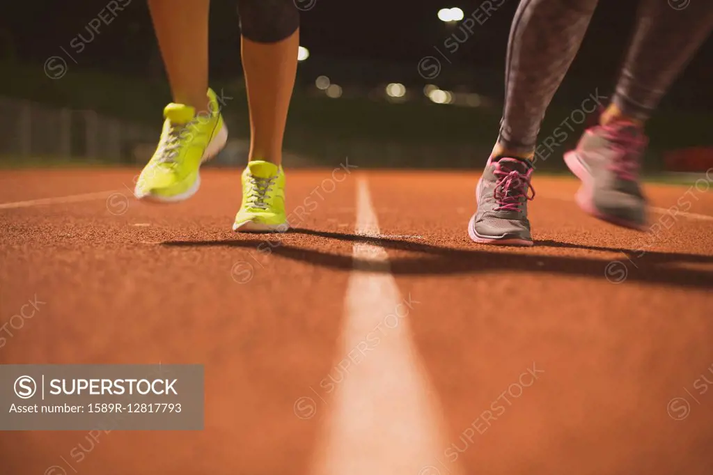 Athletes running on track on sports field