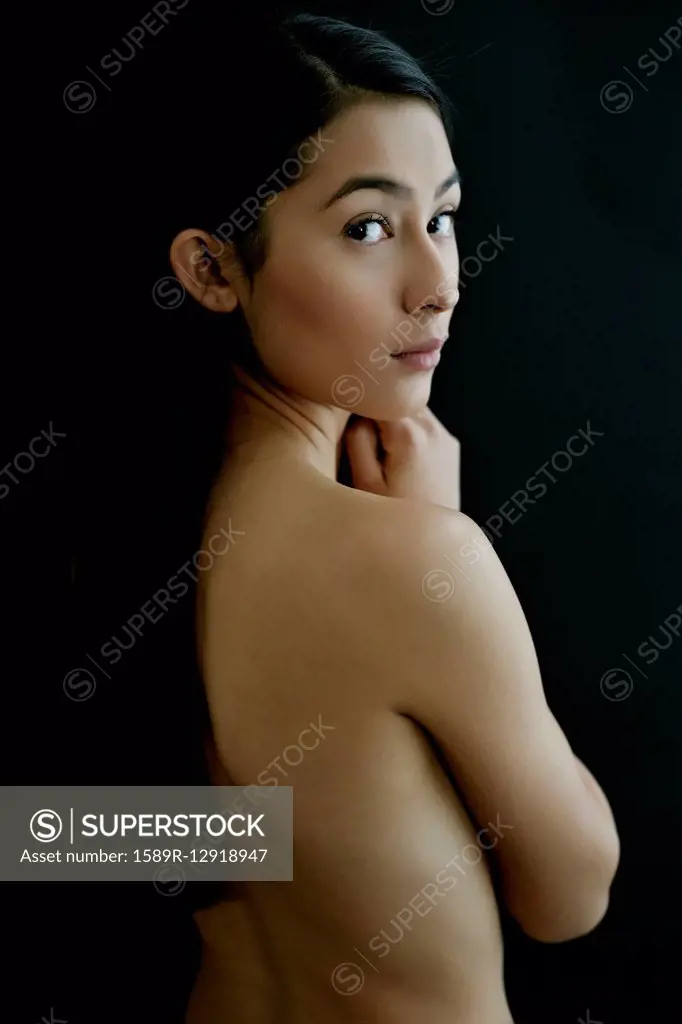 Nude Hispanic woman looking over shoulder