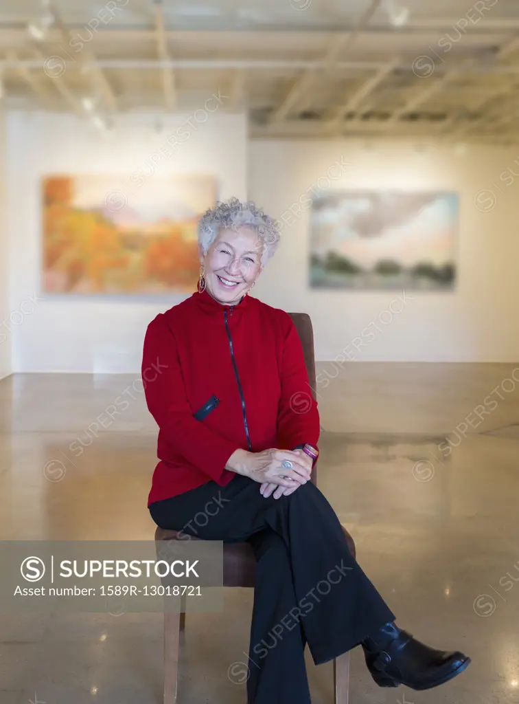 Older mixed race woman smiling in art gallery