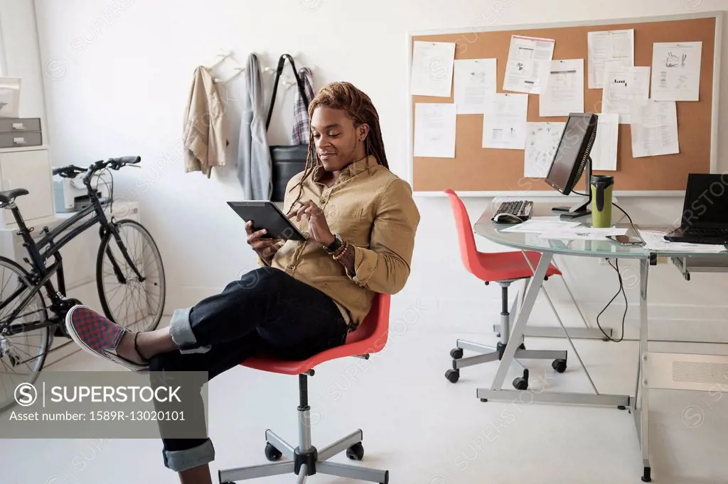 Mixed race businessman using digital tablet in office