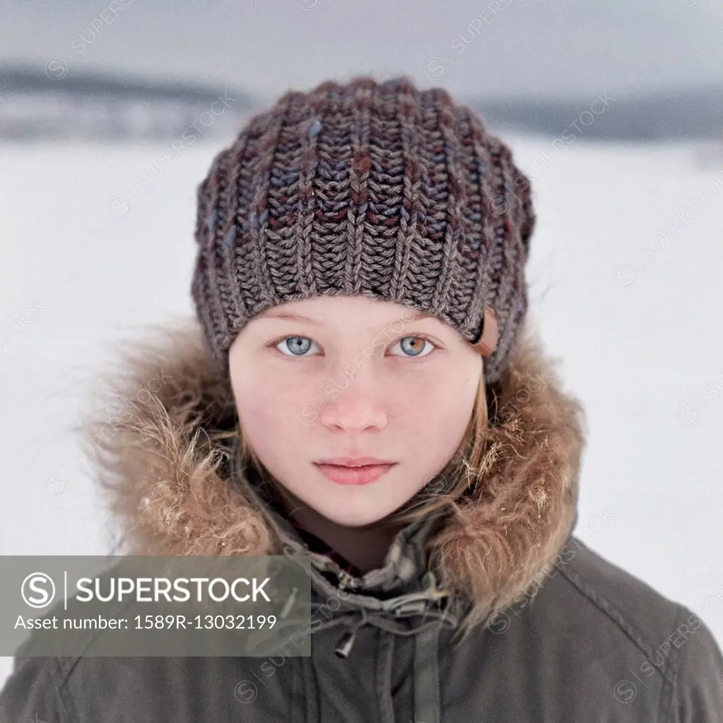 Caucasian teenage girl wearing beanie hat in snow