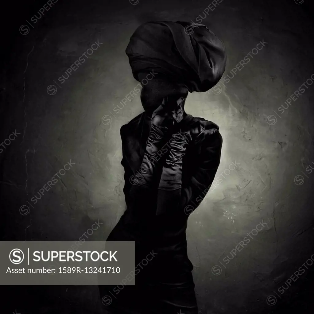 Caucasian teenager covered in black clothing and turban
