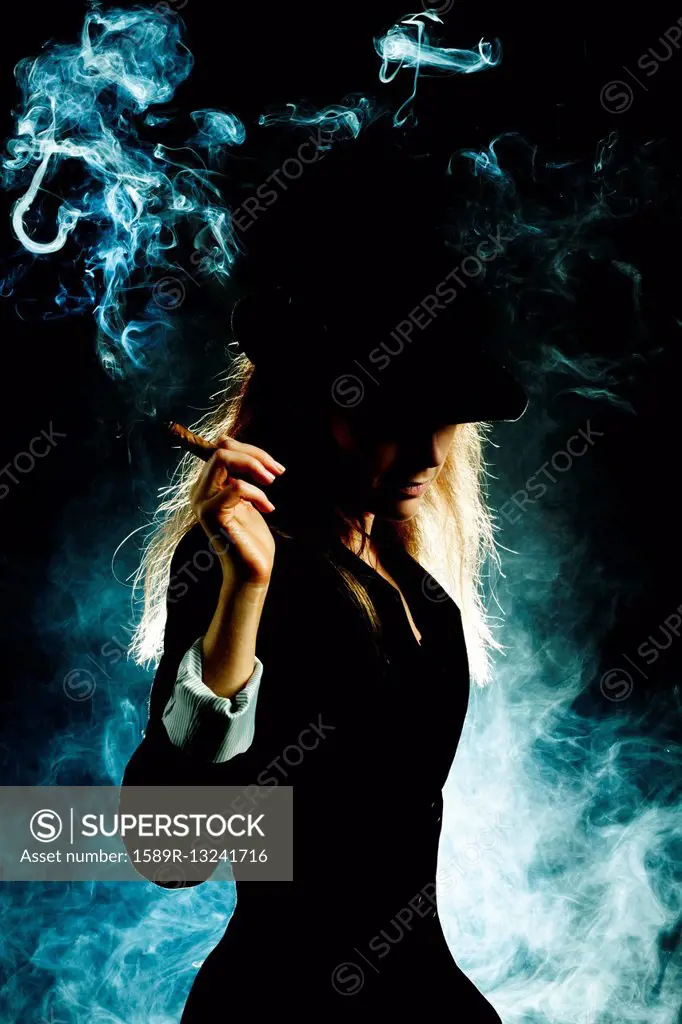 Silhouette of Caucasian woman smoking cigar