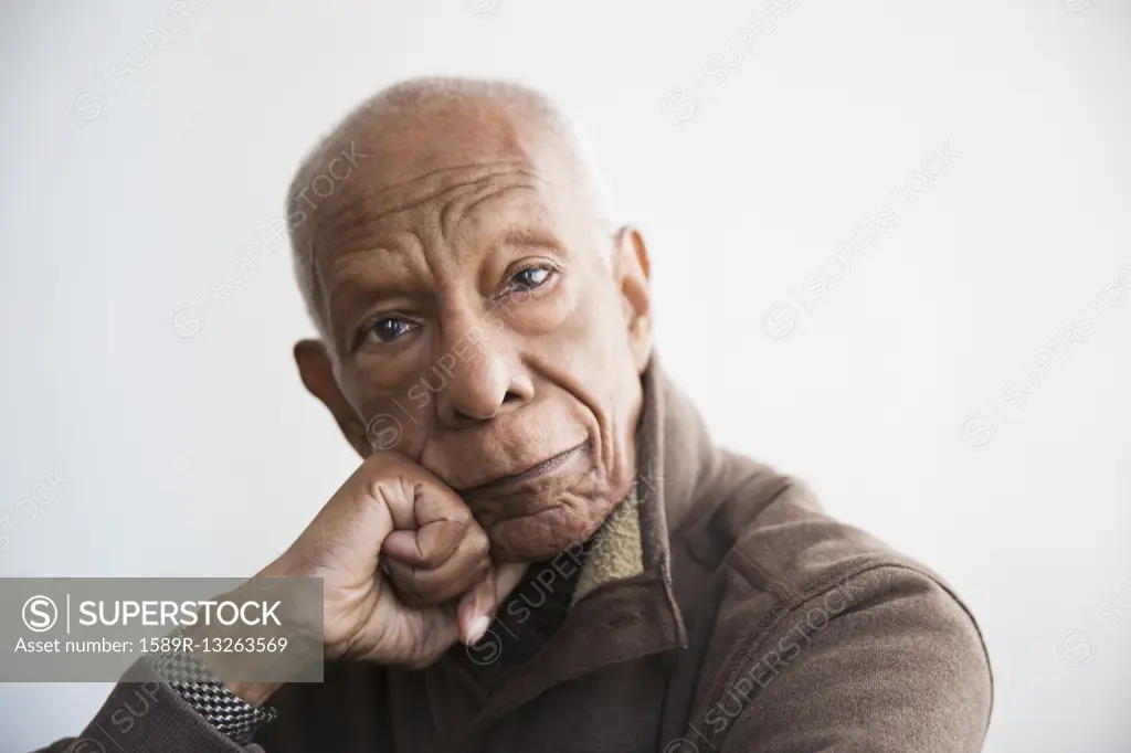 Older Black man resting chin in hand