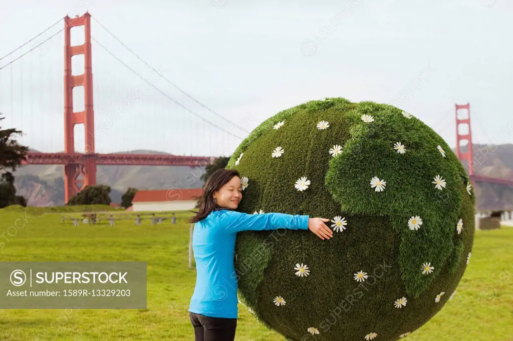 Chinese girl hugging earth topiary