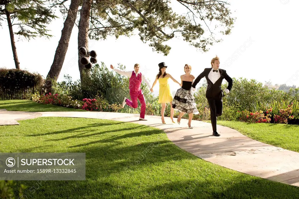 People in elegant clothing running on path in park