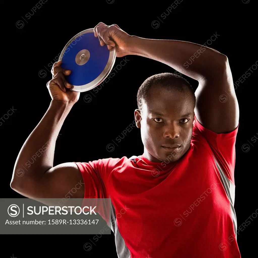 African American man holding track and field discus