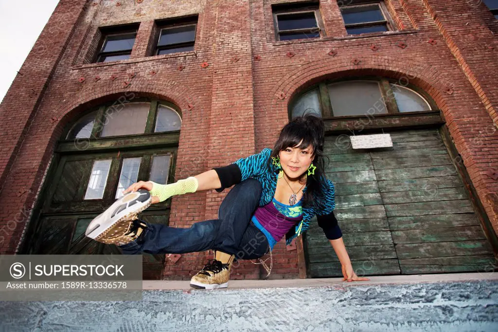 Chinese woman breakdancing in urban area