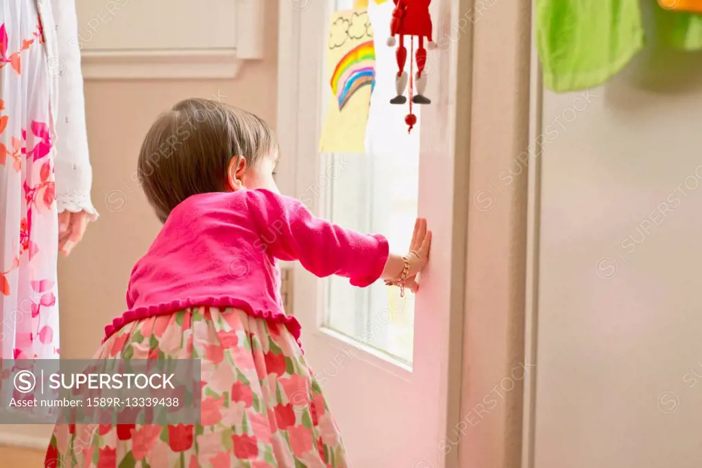 Hispanic girl looking out door