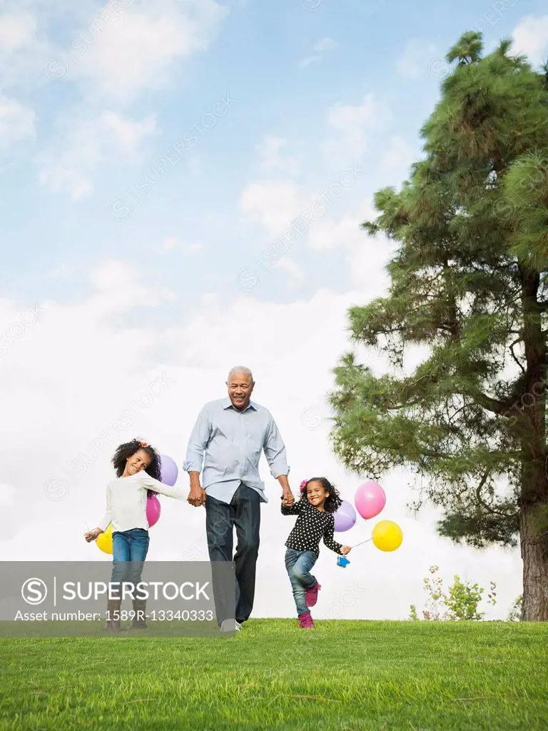 Man walking with granddaughters in park