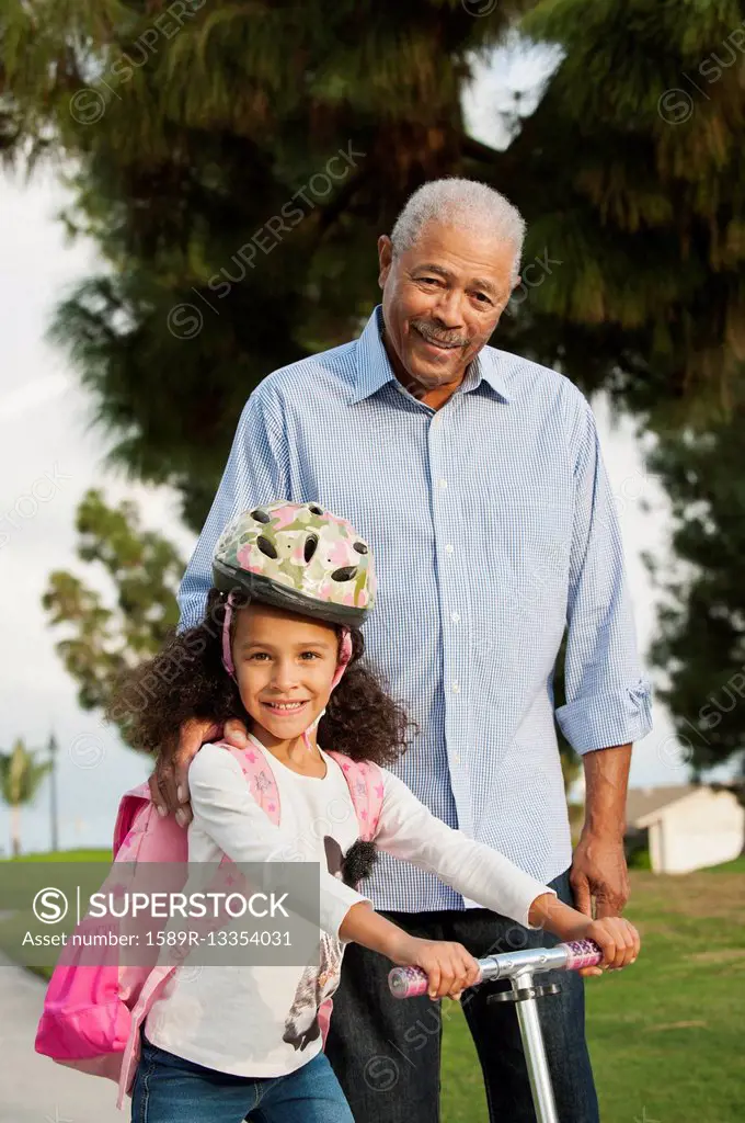 Man standing with granddaughter outdoors