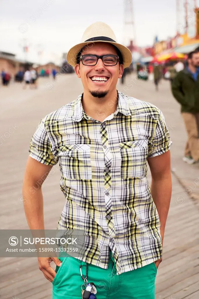 Hispanic man smiling on boardwalk