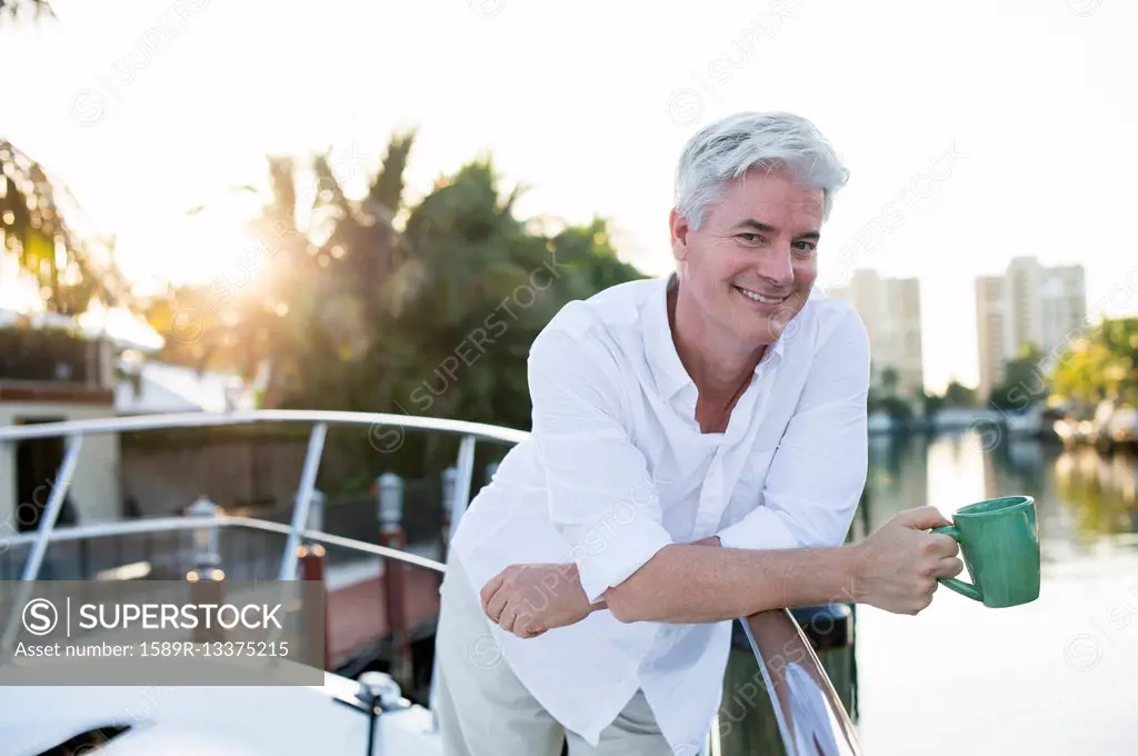 Older Caucasian having coffee on boat deck