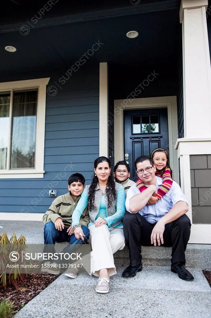 Family smiling on front stoop