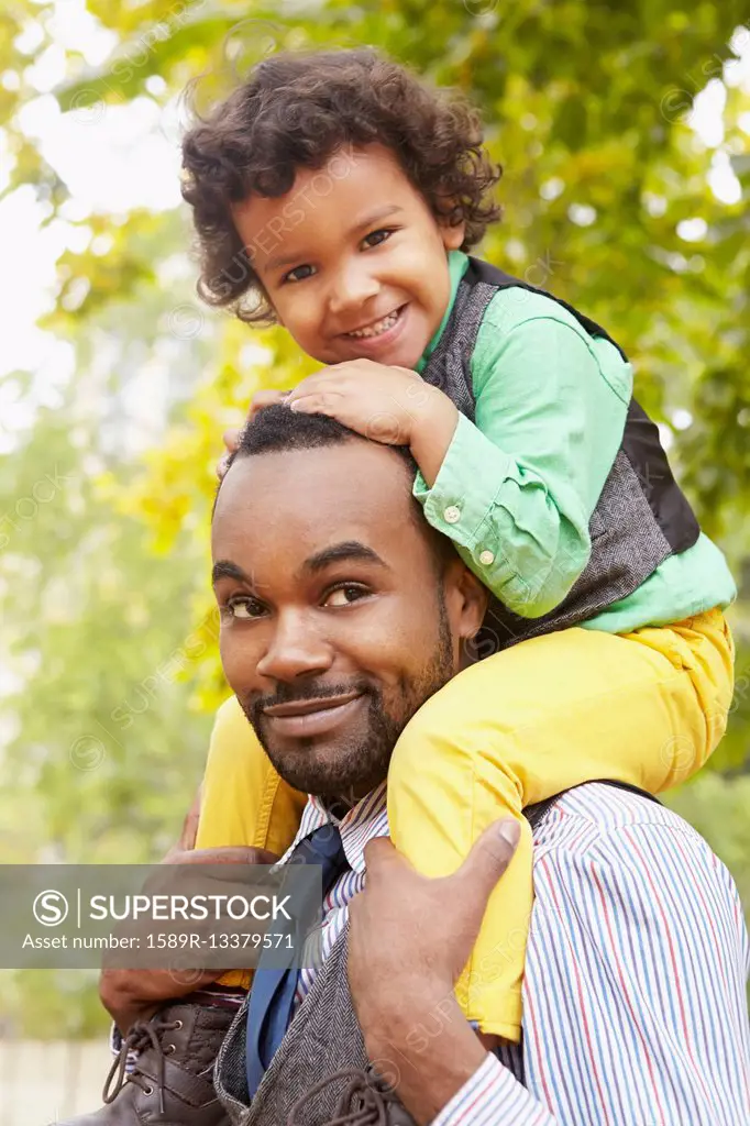 Father carrying son in park