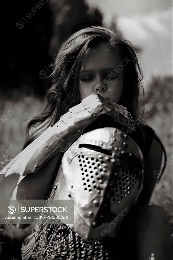 Caucasian girl carrying armor outdoors