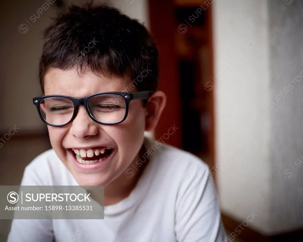 Laughing Hispanic boy wearing eyeglasses